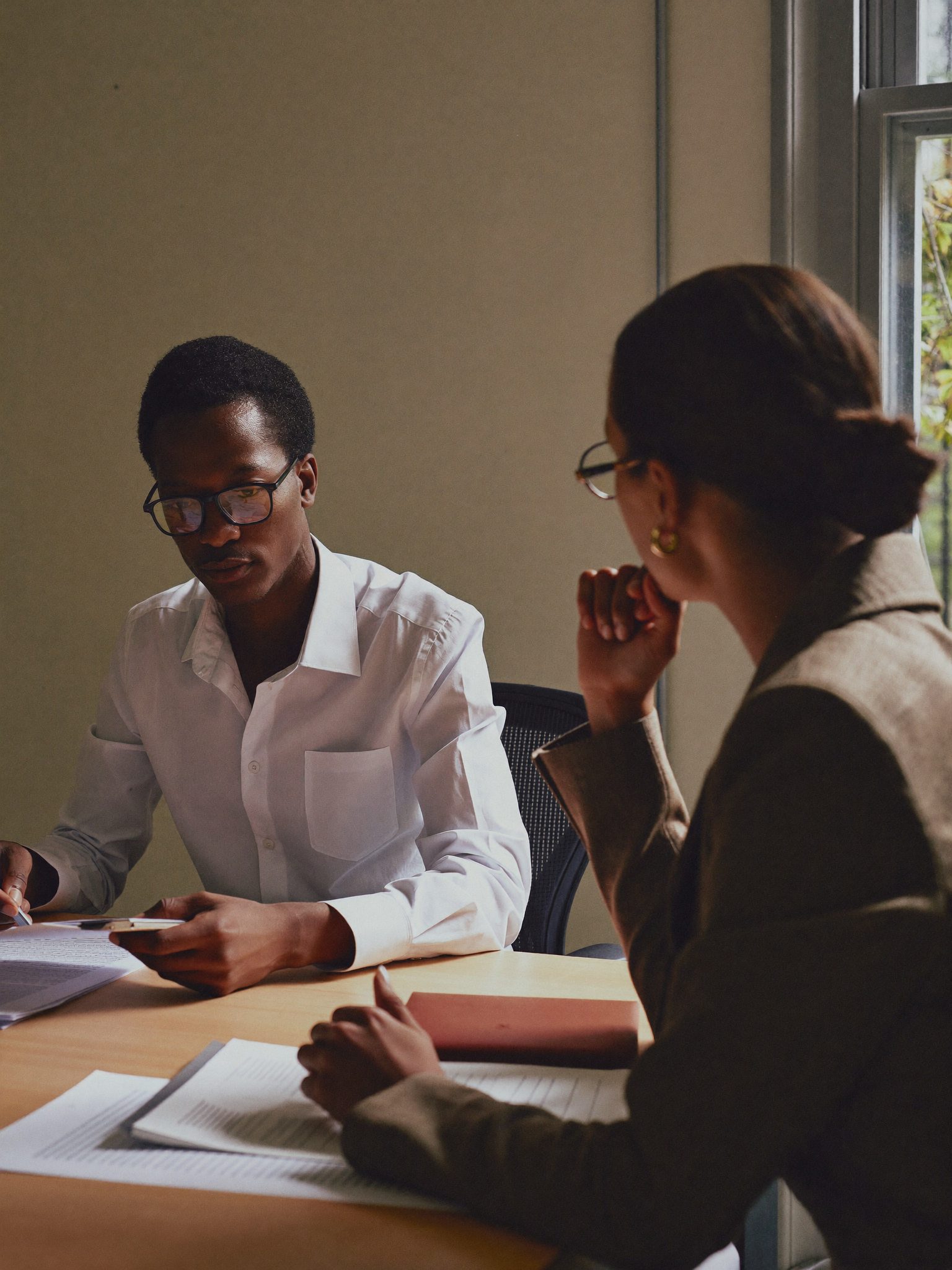Advisor and client across a desk reviewing documents